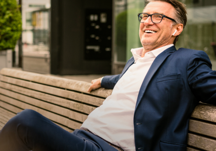 Homem de fato num banco de jardim. Representa o seguro BPI vida negócios.