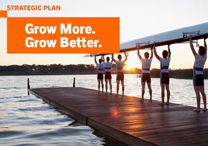 Sportsmen holding a kayak near water. Represents the growth of Banco BPI's Strategic Plan.