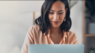 Mulher ao computador a contratar o Seguro de Crédito Smart da Cosec.