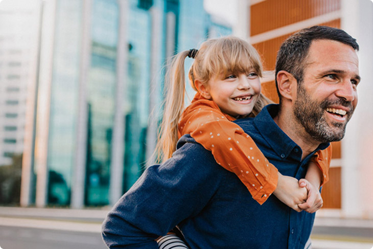 BPI Reforma Vida PPR 2040. Imagem de um pai sorridente, em casa, com uma criança sorridente às cavalitas.