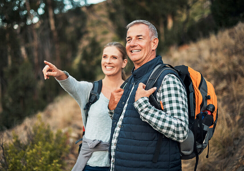 BPI Rendimento 2031 PPR. Casal a rondar os 55 anos a desfrutar de uma caminhada na montanha.