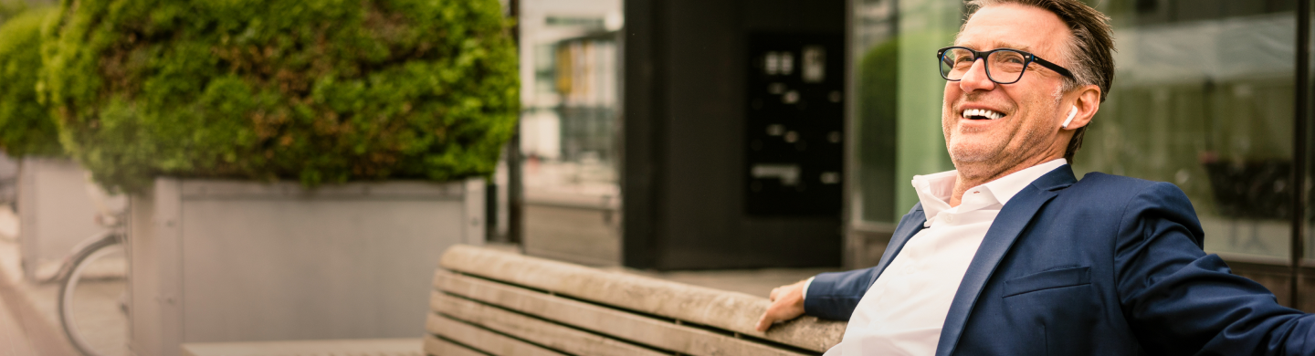 Homem de fato num banco de jardim. Representa o seguro BPI vida negócios.